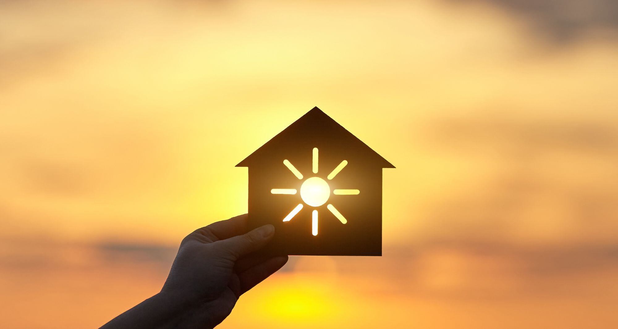 une maison miniature avec le symbole du soleil - énergie solaire