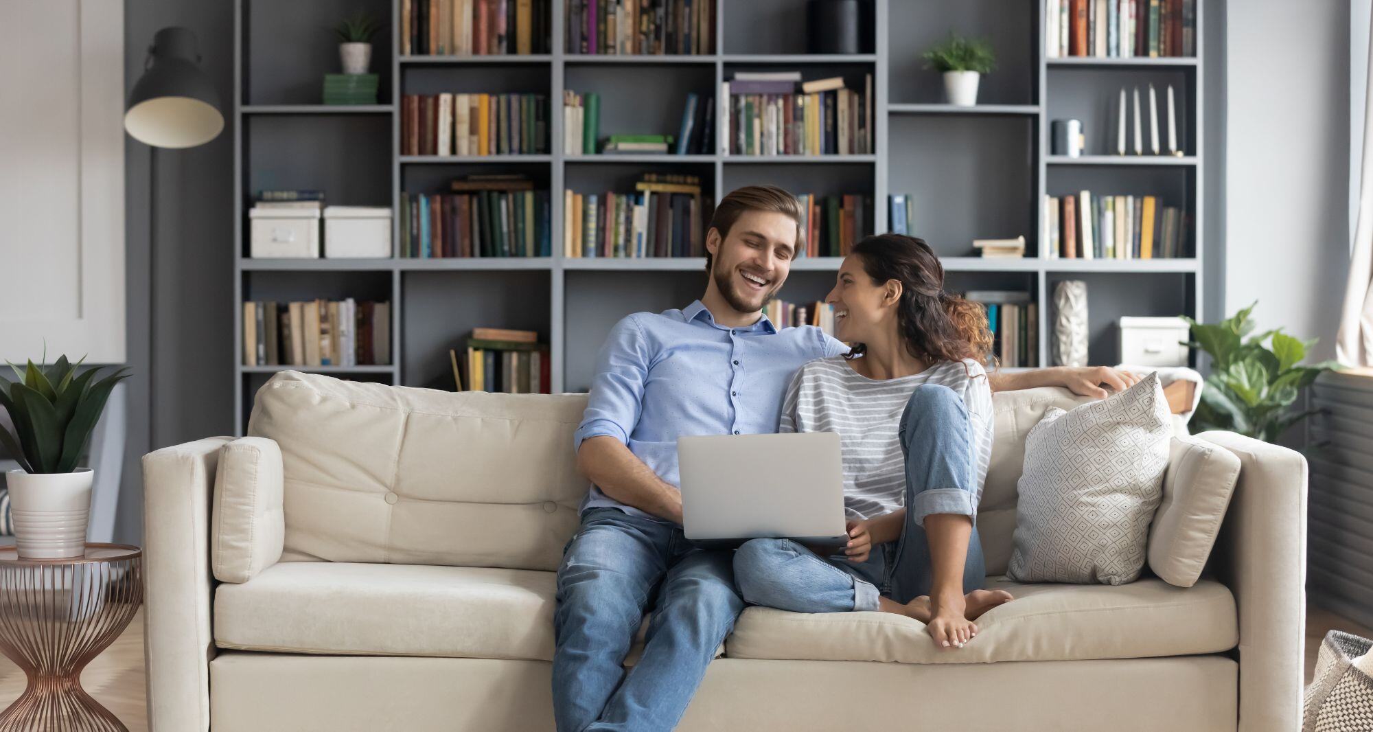 un couple assis dans le salon avec un ordinateur portable - économiser électricité 