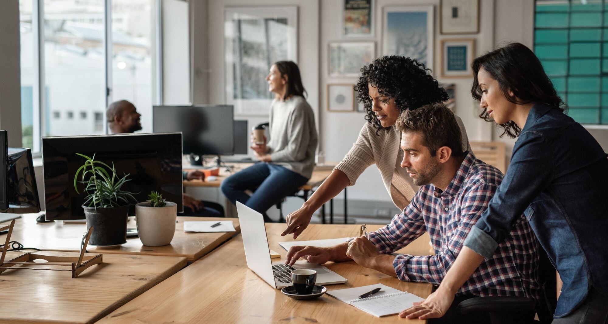 Des collaborateurs travaillent ensemble sur un ordinateur portable - rénovation énergétique entreprise 